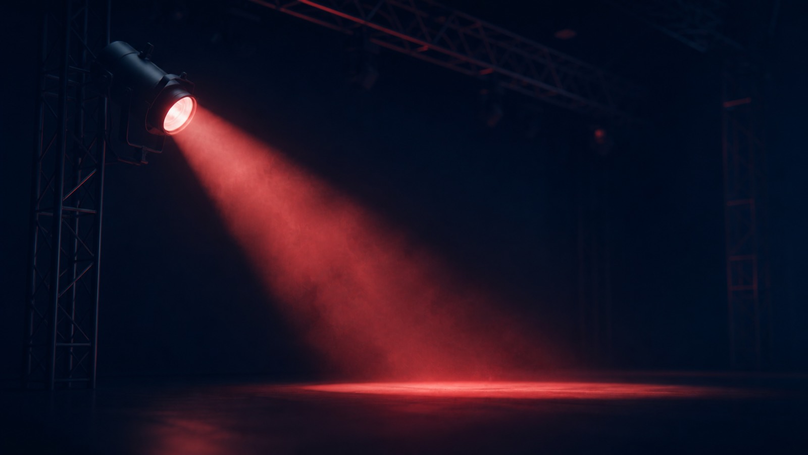 Een podiumspot verlicht een leeg podium met rigging op de achtergrond